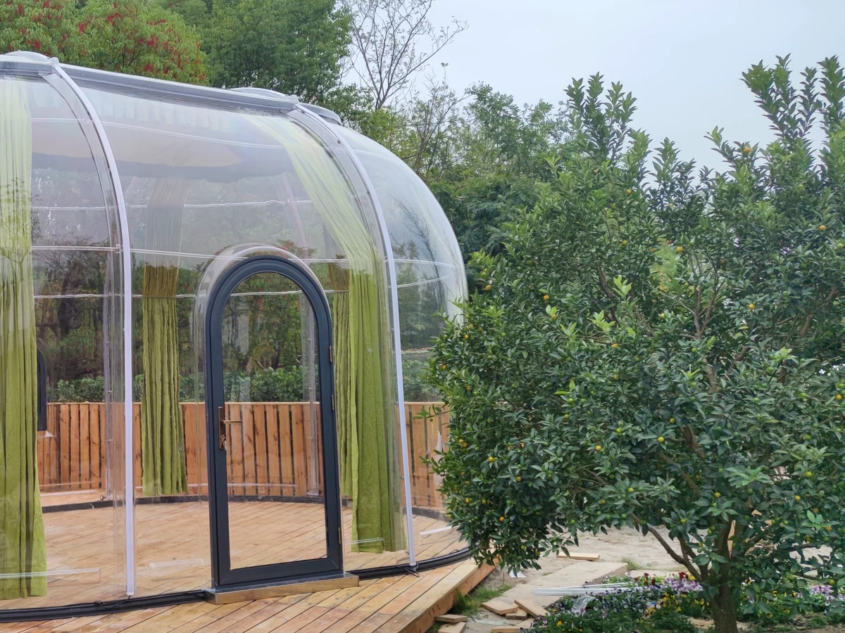 Extended oval Domevora dome on a timber deck beside a lawn