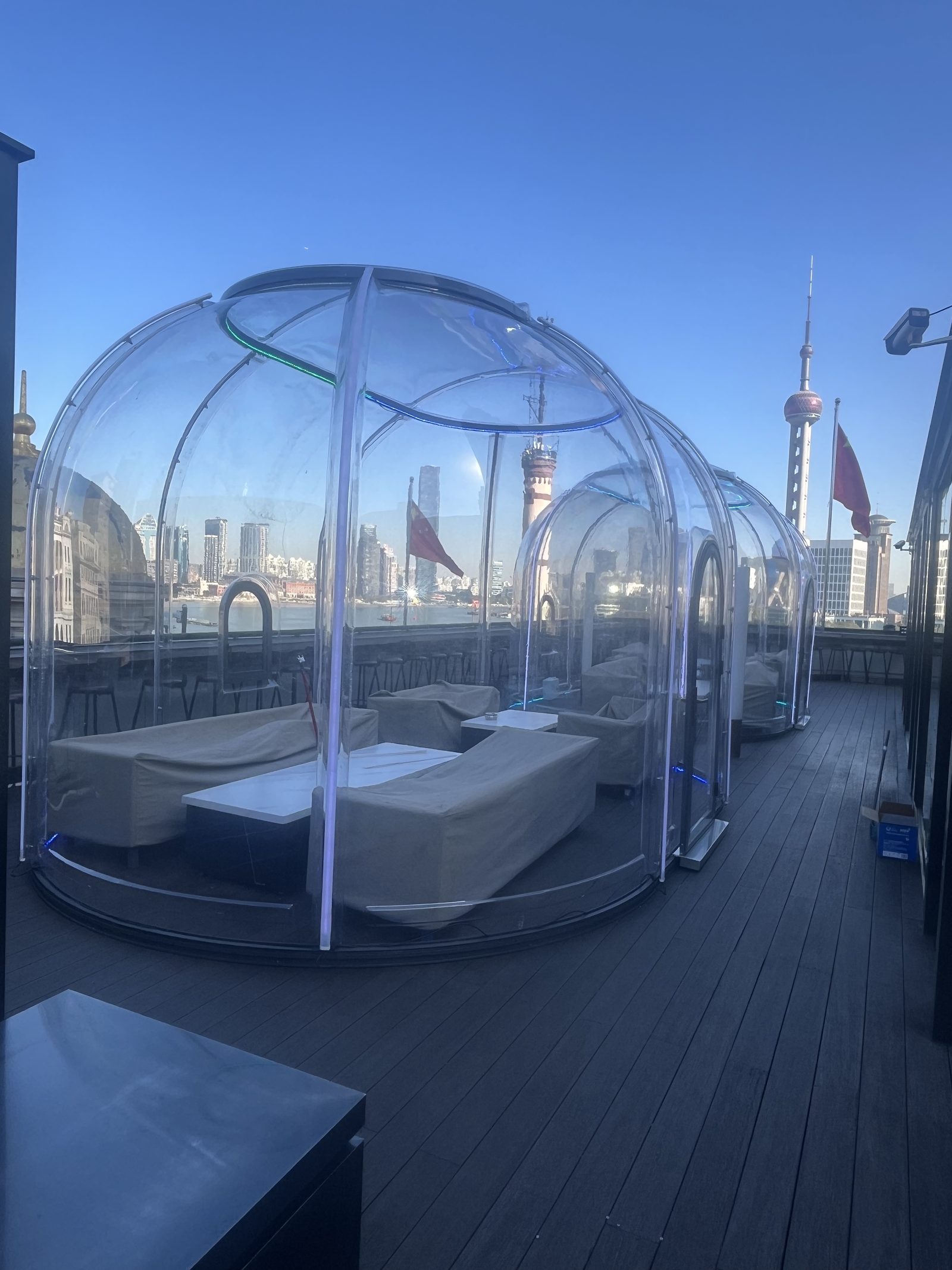 Polycarbonate dining domes on a Shanghai riverside rooftop terrace, daytime
