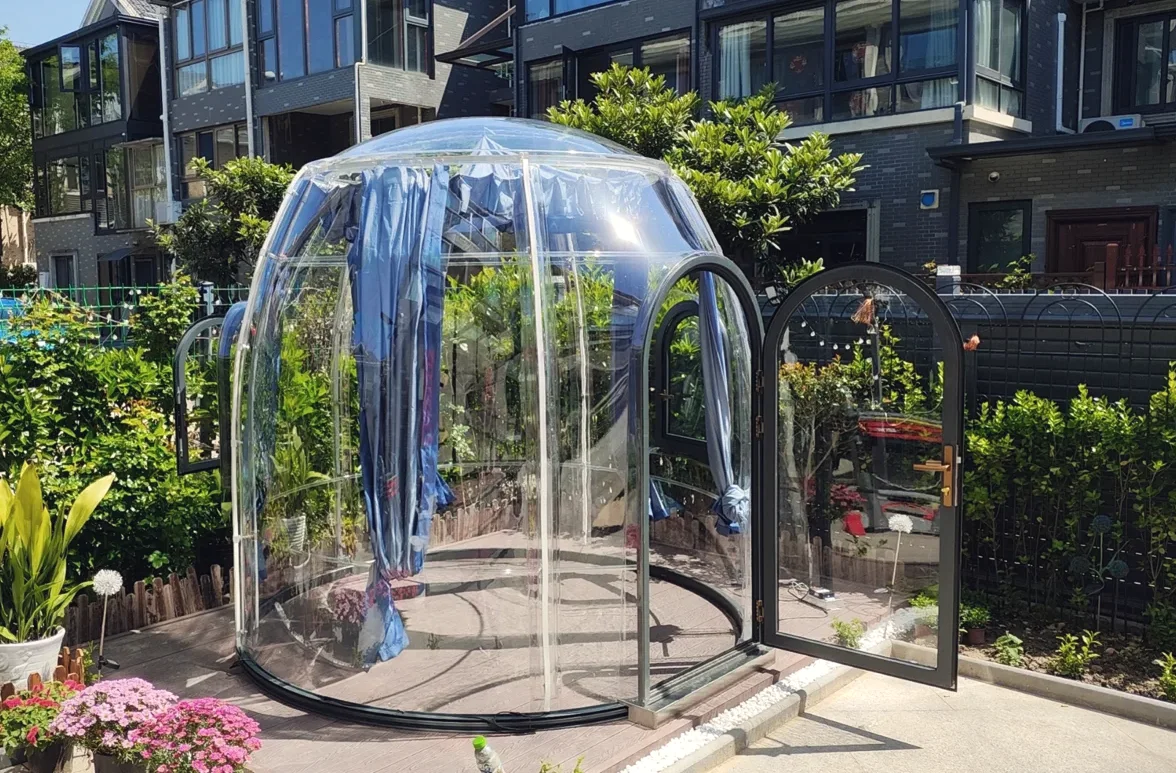 Round 2.5 m clear polycarbonate dome: a home courtyard garden, door open onto the paving