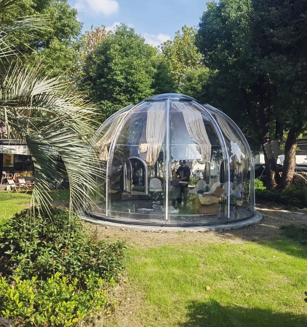 Round 5.0 m clear polycarbonate dome: in a planted garden on a lawn, curtains tied back
