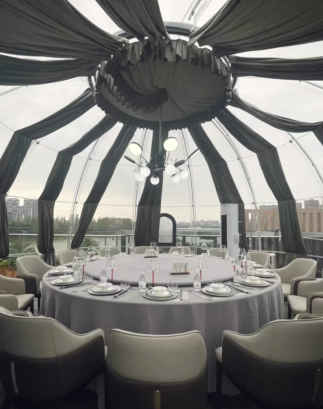 Round 6.0 m Domevora dome, client installation: inside: a banquet table for a large group under draped curtains