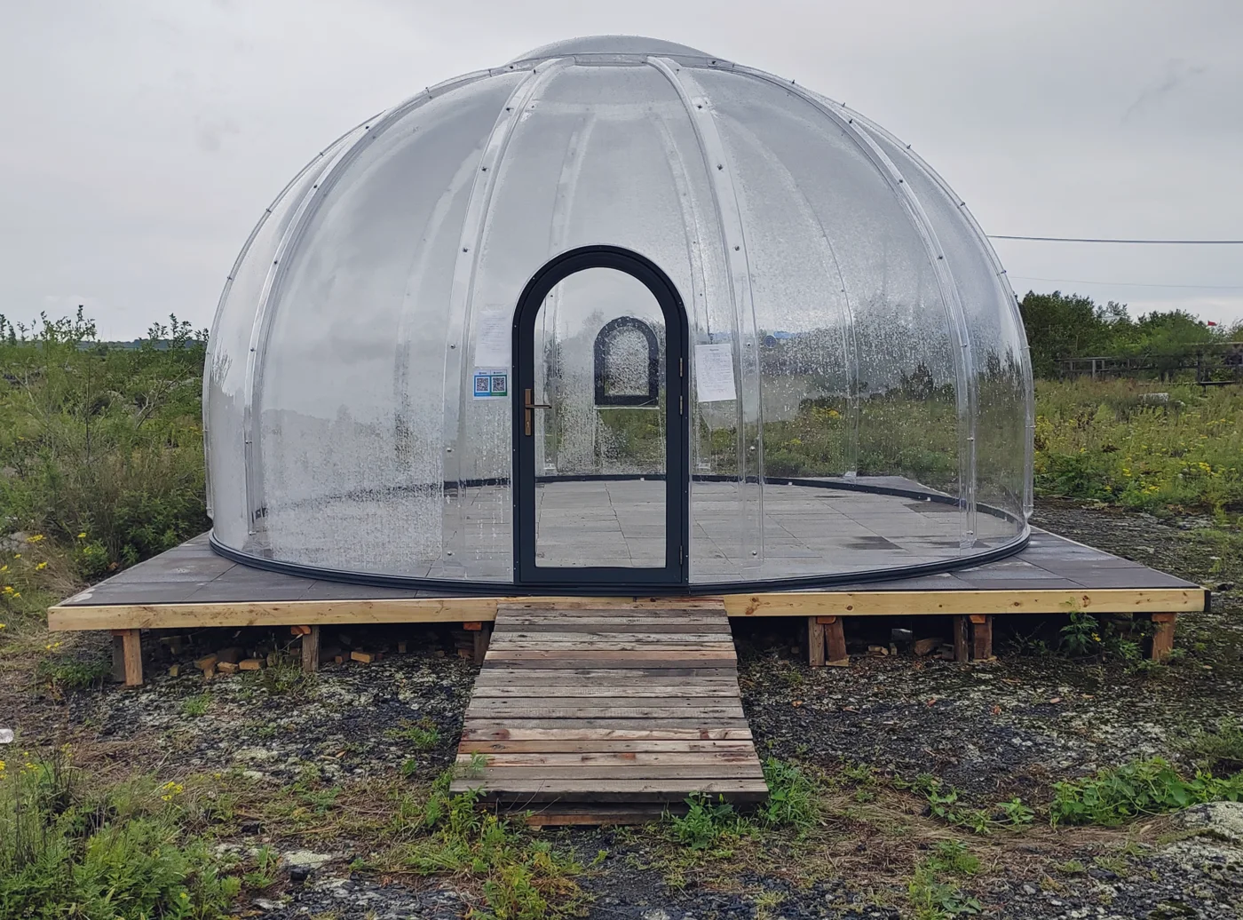 Round 6.0 m Domevora dome on a raised timber platform with a ramp, on an open rural site